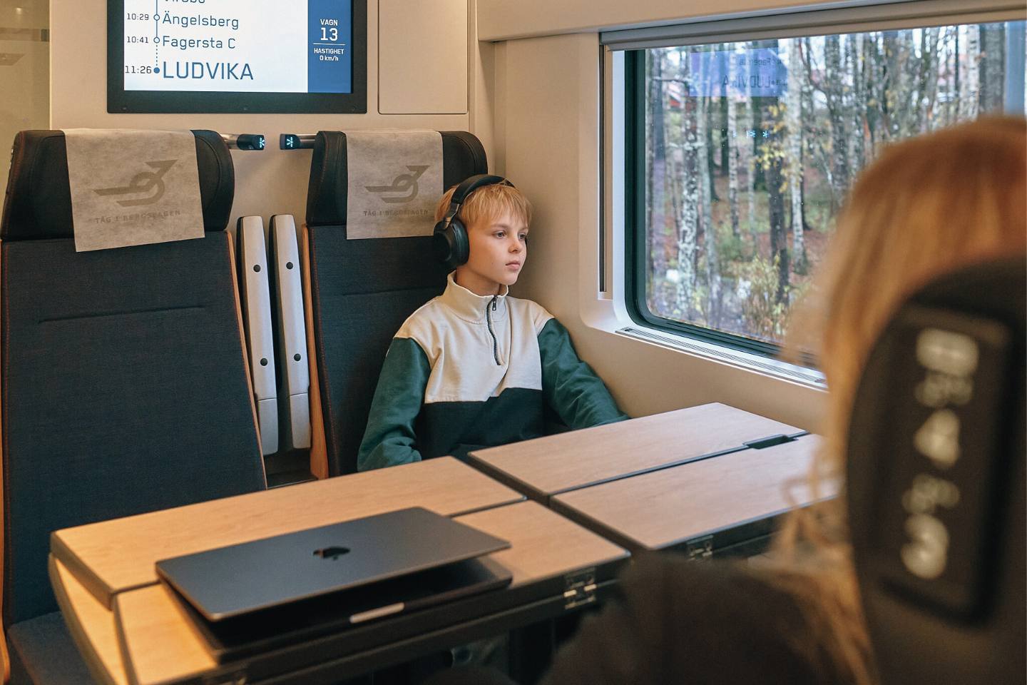 Mindfulness på tåget, ungdom som sitter och tittar ut och har hörurar på sig.